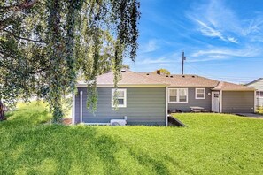 A residential house with a sloped roof, a small front porch, and a well-maintained lawn.