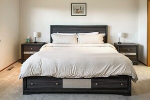 Une chambre à coucher avec un lit, deux tables de chevet et une commode.