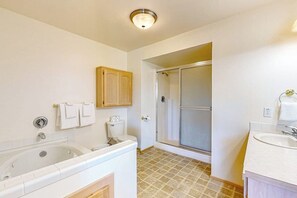 Une salle de bain équipée d’une baignoire, de toilettes, d’une douche et d’un lavabo.