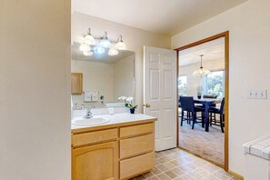A bathroom with a double sink vanity, a mirror, and a chandelier.