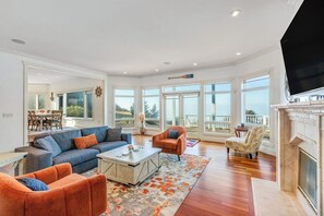 A spacious living room with a large sofa, armchairs, a coffee table, and a fireplace. - Stunning Dog Friendly Waterfront Villa with Sunset Views and Fireplace (Oak Harbor)