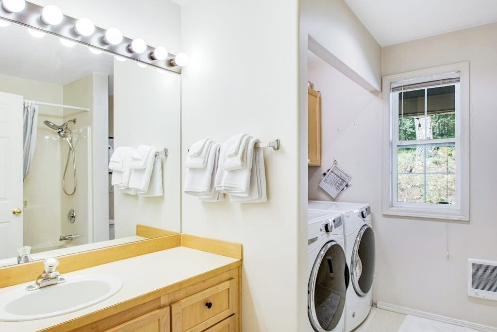 A bathroom with a sink, mirror, and towels.