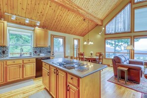 A spacious kitchen with wooden cabinets, a central island, and large windows.