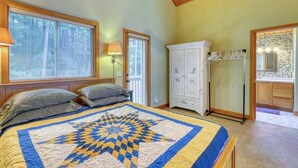 Ein Schlafzimmer mit einem großen Bett, einem Kleiderschrank und einem durchgehenden Türspalt sichtbaren Badezimmer.