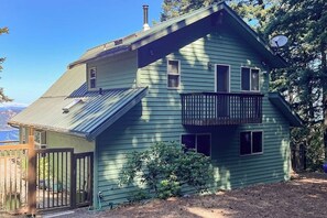 A two-story house with a balcony, a fenced yard, and a satellite dish.