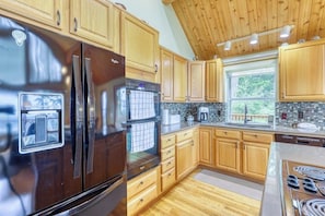 Una cucina con mobili in legno, elettrodomestici in acciaio inossidabile e una finestra che offre luce naturale.