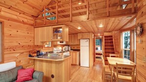 A cabin interior with a kitchen, dining area, and a couch. - Cozy 1BR Waterfront Cabin with Mountain Views (Eastsound)