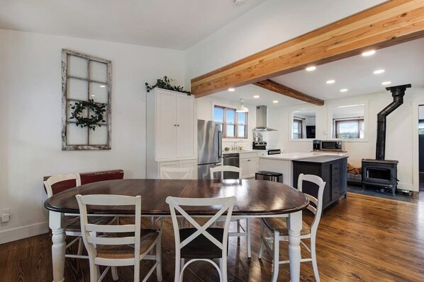 A modern kitchen with white cabinetry, a wooden ceiling, and a central island.