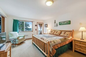 A bedroom with a bed, a chair, a desk, and a window. - Waterfront Cabin with Hot Tub and Mountain Views in Eastsound (Eastsound)