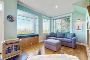 A modern living room with a sectional sofa, a built-in bench, and a wood-burning stove.