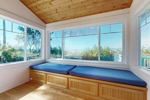 A room with large windows, wooden bench seating, and a view of the outdoors.