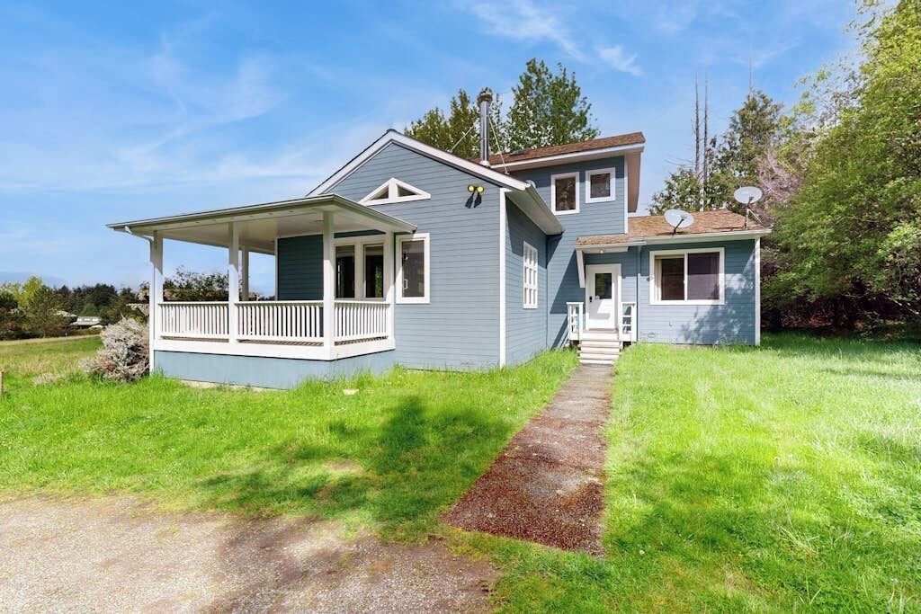Ett tvåvåningshus med en veranda, en överbyggd entré och en satellantenn.