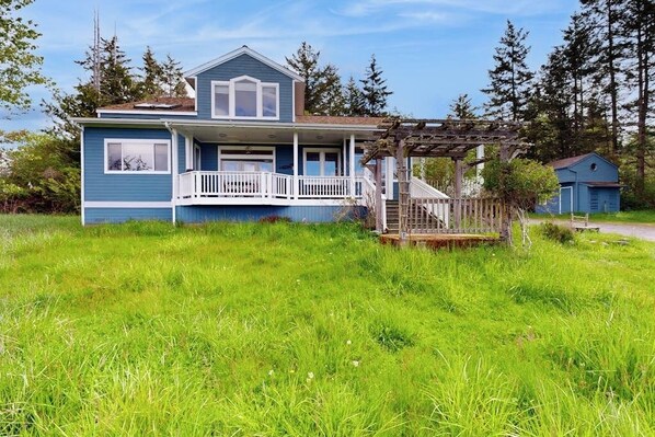 A two-story house with a porch and a wooden deck.