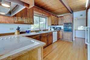 A kitchen with wooden cabinets, a built-in microwave, and a dishwasher.