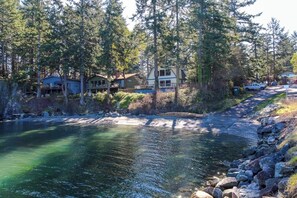 A lakeside property with multiple houses, a dock, and a clear view of the water.