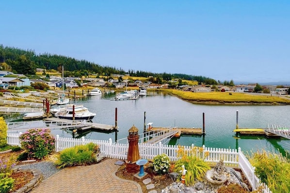 A marina with boats docked, a white picket fence, and a small lighthouse. - Waterfront Home with Private Sauna and Kayaks in Oak Harbor (Oak Harbor)