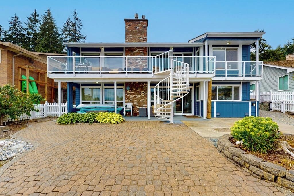 A two-story house with a central staircase, a front porch, and a swimming pool.