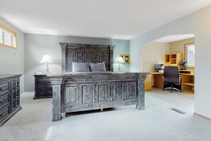A bedroom with a large bed, bedside tables, a desk, and a chair. - Waterfront Home with Private Sauna and Kayaks in Oak Harbor (Oak Harbor)
