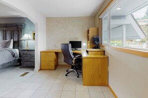 A bedroom with a bed, bedside table, lamp, desk, chair, computer, and a window with a view. - Waterfront Home with Private Sauna and Kayaks in Oak Harbor (Oak Harbor)