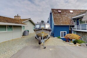 A boat parked in a driveway with houses on either side. - Waterfront Home with Private Sauna and Kayaks in Oak Harbor (Oak Harbor)