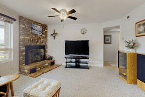 A living room with a fireplace, television, and ceiling fan. - Waterfront Home with Private Sauna and Kayaks in Oak Harbor (Oak Harbor)