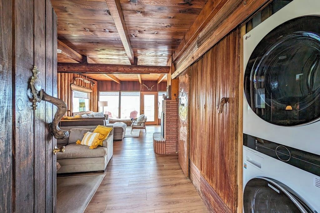 Un interior de madera con zona de lavandería, un sofá y comedor.
