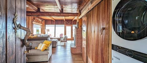 Un interior de madera con zona de lavandería, un sofá y comedor.