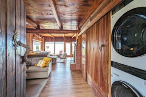 Un intérieur en bois comprenant un espace buanderie, un canapé et un coin repas.