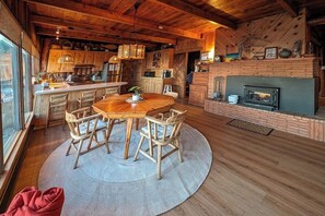 Ein rustikales Holzinnenambiente mit Essbereich, Küche und Kamin.