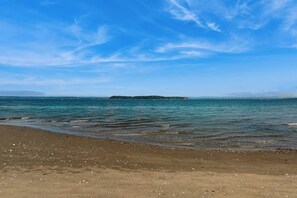 Une plage avec un ciel dégagé et une mer calme.