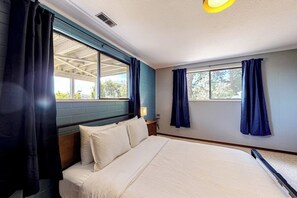 Ein Schlafzimmer mit einem Bett, einem Fenster und Vorhängen.