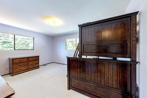 A room with a large wooden cabinet, a dresser, and two windows. - Hawk Lane Hideaway: Spacious 4 Bedroom Waterfront Retreat with Hot Tub (Greenbank)