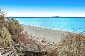 A beach with a wooden staircase leading down to the shore, surrounded by dry vegetation. - Eastside Beachside Greenbank Getaway (Greenbank)