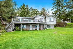 A two-story house with a covered porch and a staircase leading to a balcony. - Eastside Beachside Greenbank Getaway (Greenbank)