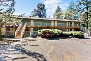 A two-story building with a balcony, a staircase, and a parking area. - Stunning 3 Ocean View Condos near Moran State Park with Balconies (Eastsound)