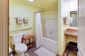 A bathroom with a toilet, a shower, and a bathtub.