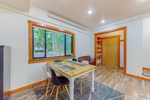 A dining area with a table and chairs, a window with a view of trees, and a door leading to another room. - Peaceful 1BR Pet Friendly House Near Langley (Langley)