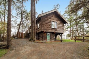 A rustic cabin with a wooden exterior, a front porch, and a staircase leading to a deck. - Secluded and Stylish Cabin in Eastsound Near Beach and Town (Eastsound)