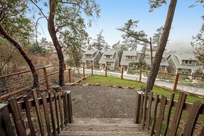 Una escalera de madera que lleva a una zona residencial con casas y un césped.