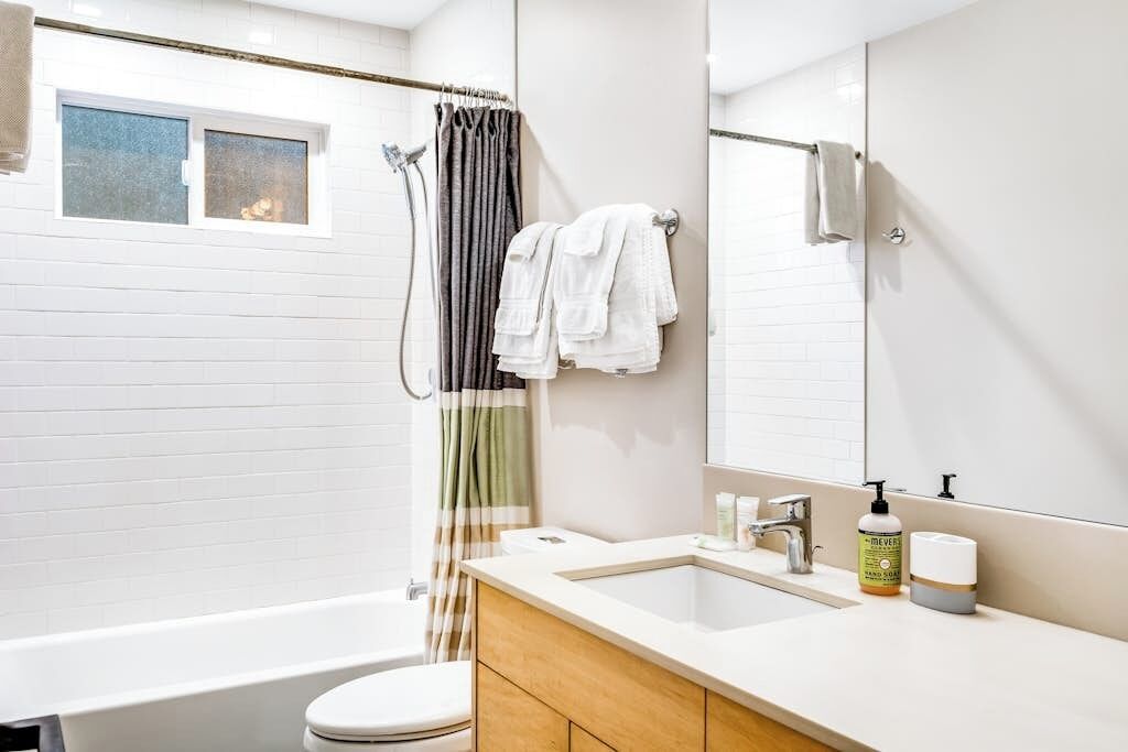 Ein modernes Badezimmer mit Badewanne, Toilette und einem Waschtisch mit Spiegel.