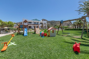 Ein Spielplatz mit Rutsche, Schaukeln und Klettergerüsten.