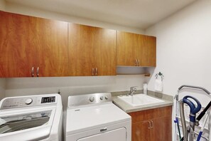 A laundry area with a washing machine, dryer, and a sink. - Pet Friendly Waterfront Escape with Fire Pit, Hot Tub and Mountain Views on Lopez Island (Lopez Island)