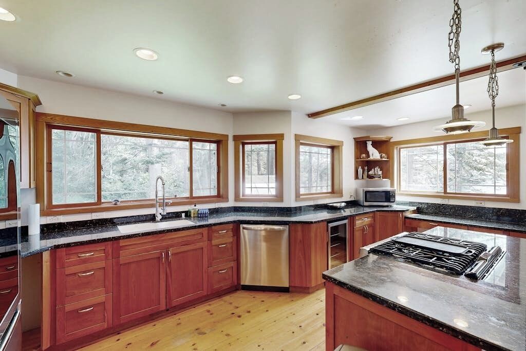 A kitchen with wooden cabinets, a stainless steel dishwasher, a microwave, and a gas stove.