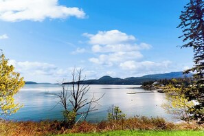 Un llac tranquil amb muntanyes al fons i un cel serè.