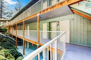 A multi-story building with balconies, a staircase, and a covered outdoor area.