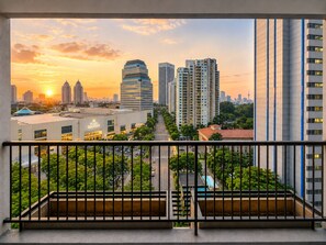 A cityscape view from a balcony with high-rise buildings, a clear sky, and a sunset. - Solana ONE By SanLiving - Senayan (Jakarta)