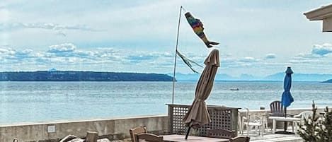 Une terrasse avec des sièges extérieurs donnant sur un plan d’eau.