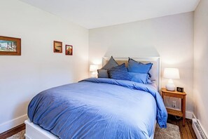 Ein Schlafzimmer mit einem Bett, Nachttischen und Wandleuchten.