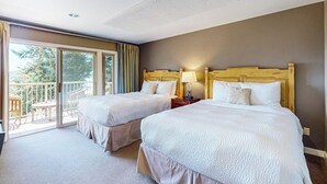 A hotel room with two beds, a balcony, and a view of the outdoors. - Wonderful Waterfront Escape with Three Balconies and Gas Fireplace (Eastsound)