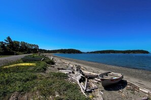 Ein Strand mit Booten und Treibholz.